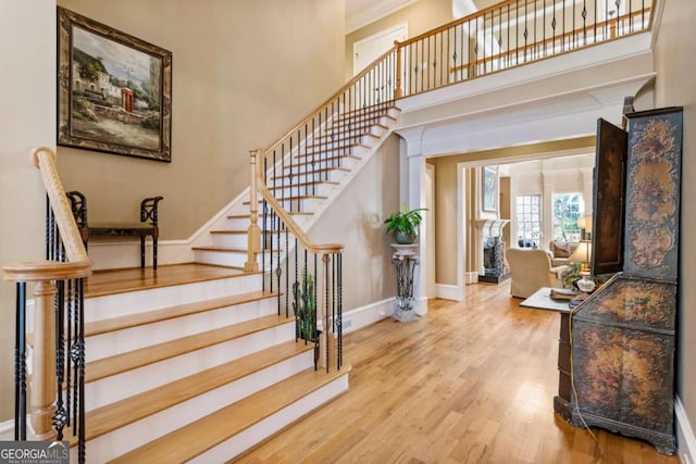 stairs with wood-type flooring and a towering ceiling