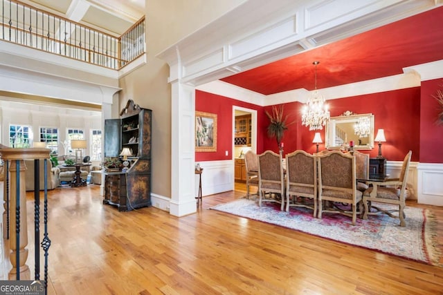 dining room with a notable chandelier, wood-type flooring, and ornamental molding