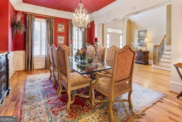 dining area featuring light hardwood / wood-style flooring, an inviting chandelier, and ornamental molding