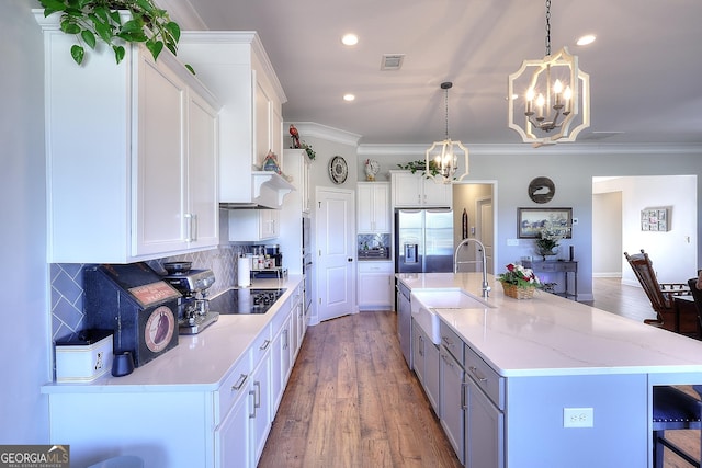 kitchen featuring hanging light fixtures, white cabinetry, tasteful backsplash, and a spacious island