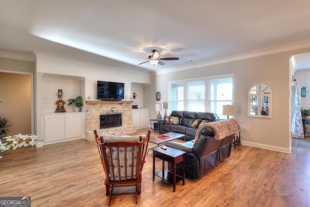 living room with ceiling fan, light wood-type flooring, and crown molding