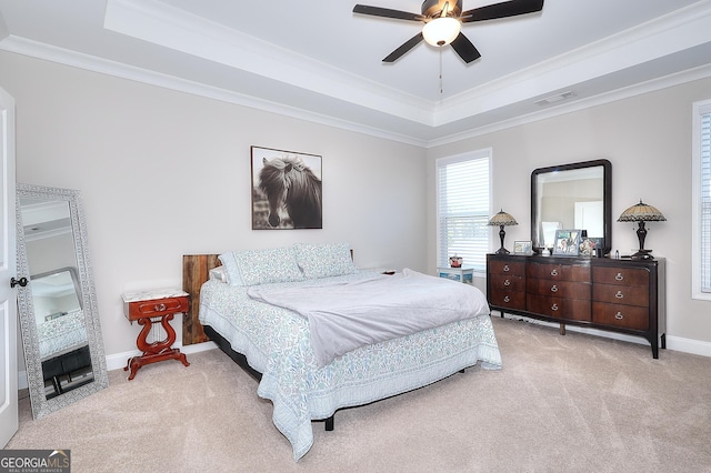 carpeted bedroom featuring ceiling fan, crown molding, and a raised ceiling