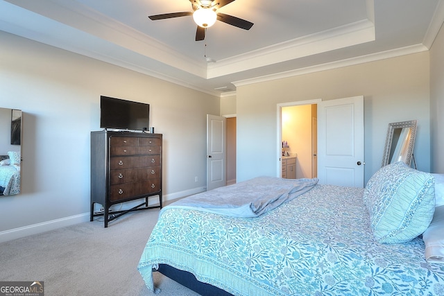 carpeted bedroom with a raised ceiling, ceiling fan, crown molding, and connected bathroom