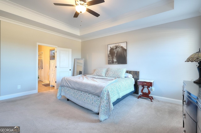 carpeted bedroom with ceiling fan, a tray ceiling, and crown molding