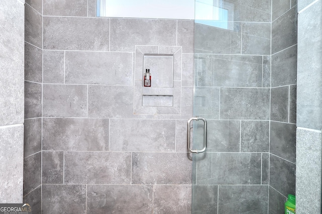 bathroom with a shower with door