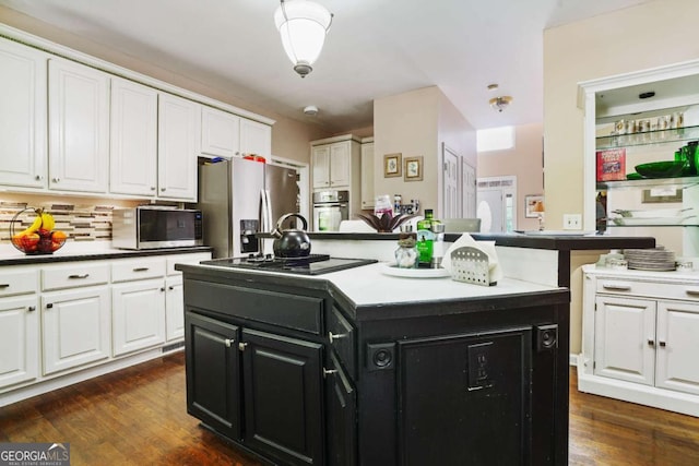 kitchen featuring white cabinets, dark hardwood / wood-style flooring, an island with sink, and stainless steel appliances