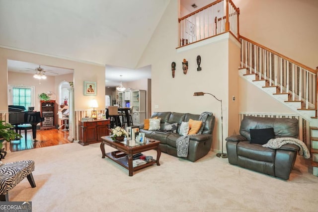 carpeted living room with high vaulted ceiling and ceiling fan