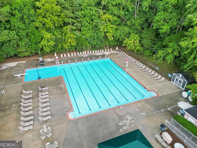 view of pool with a diving board and a patio area