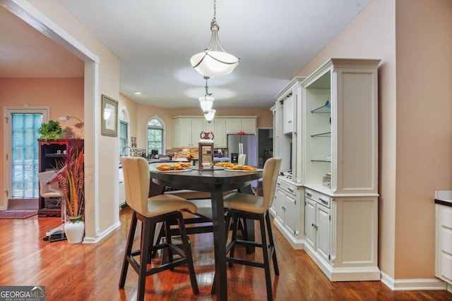 dining space with wood-type flooring