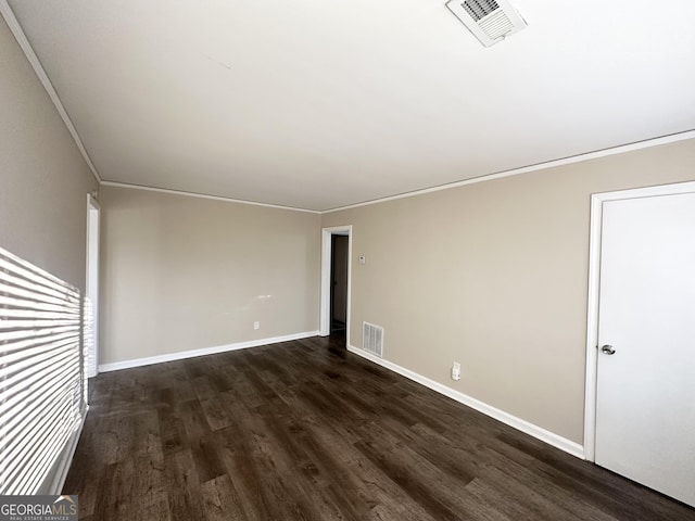 spare room with ornamental molding and dark wood-type flooring