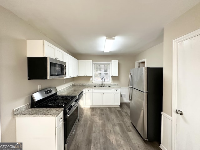 kitchen featuring sink, white cabinets, hardwood / wood-style floors, and appliances with stainless steel finishes