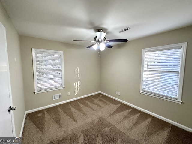 spare room with carpet flooring, ceiling fan, and a healthy amount of sunlight