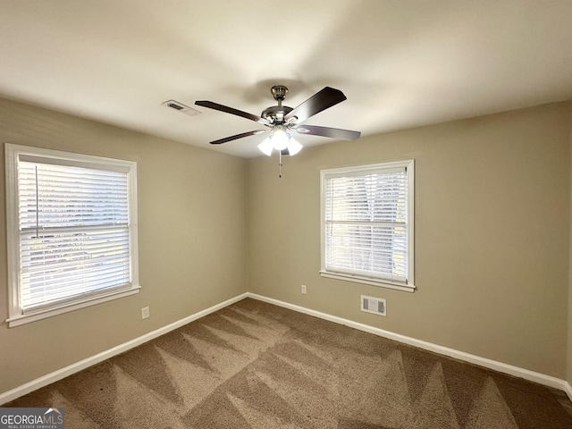 carpeted spare room featuring ceiling fan