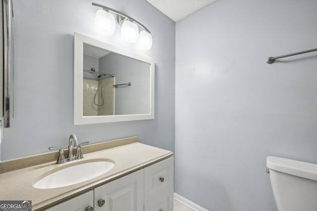 bathroom with a shower, vanity, and toilet