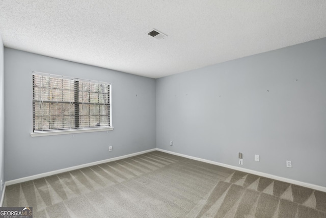 carpeted empty room with a textured ceiling