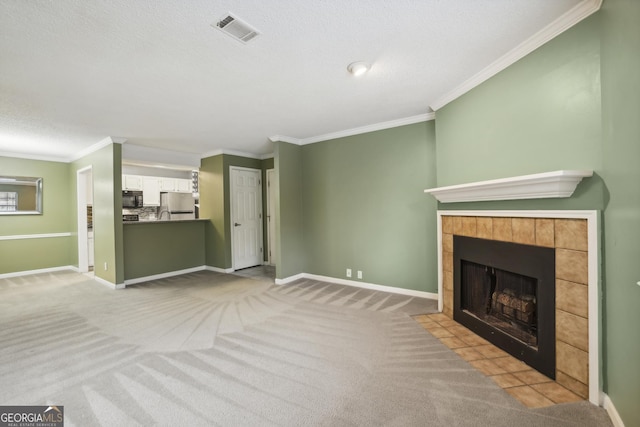 unfurnished living room featuring a tiled fireplace, light carpet, and crown molding