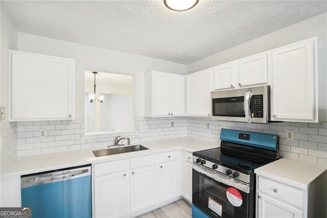 kitchen featuring white cabinetry, sink, a textured ceiling, appliances with stainless steel finishes, and light wood-type flooring