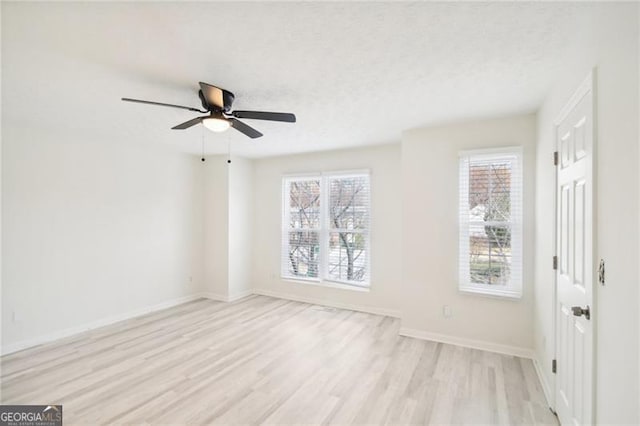 empty room with ceiling fan, light hardwood / wood-style floors, and a textured ceiling