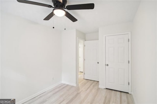 unfurnished bedroom with ceiling fan, light hardwood / wood-style floors, and a closet