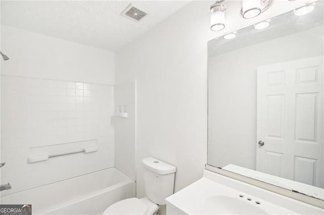 full bathroom with vanity, tiled shower / bath, and toilet