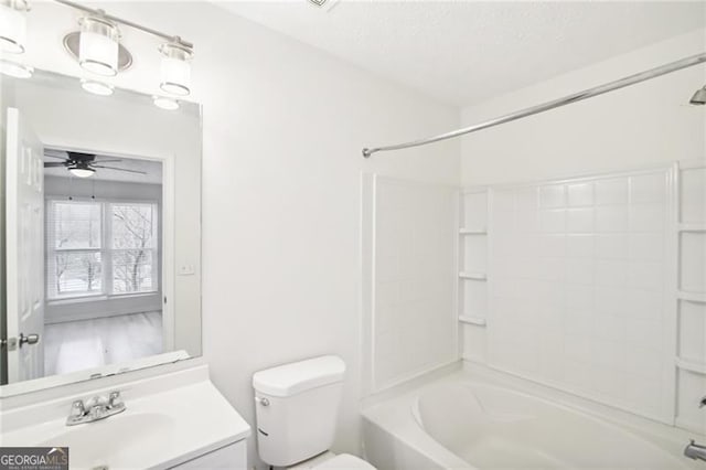 full bathroom featuring vanity, ceiling fan, toilet, a textured ceiling, and shower / bath combination