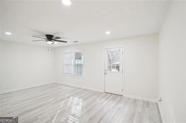 empty room with ceiling fan and light hardwood / wood-style flooring