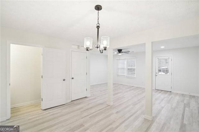 unfurnished dining area featuring light hardwood / wood-style floors and ceiling fan with notable chandelier