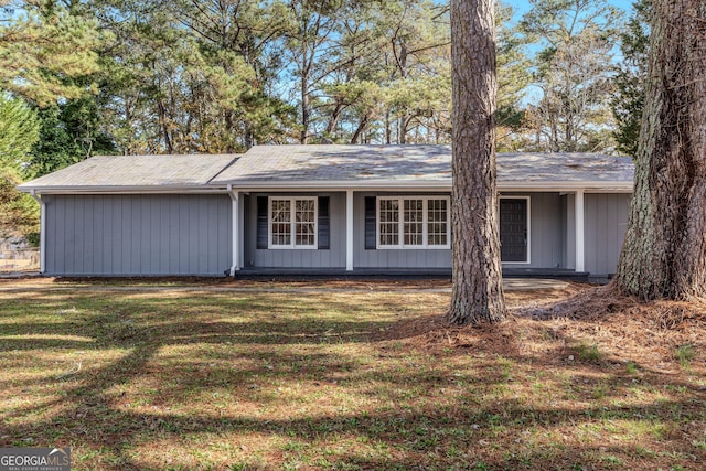 rear view of property featuring a lawn