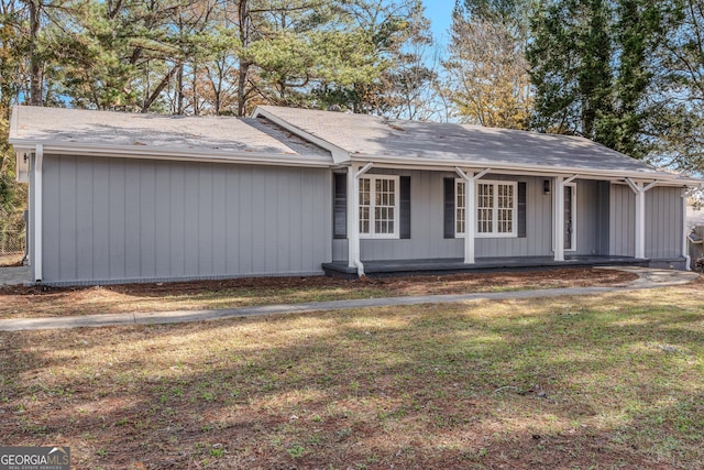 single story home with a front lawn and covered porch