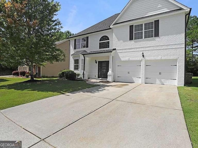 view of property with a front yard and a garage