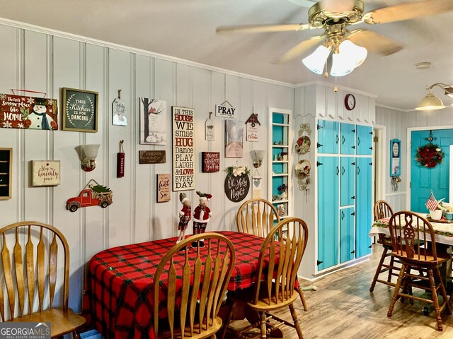 dining room with light wood-type flooring, ceiling fan, and ornamental molding