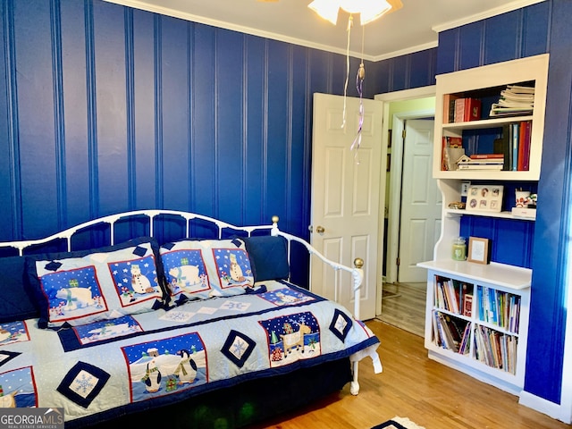 bedroom with crown molding and hardwood / wood-style flooring