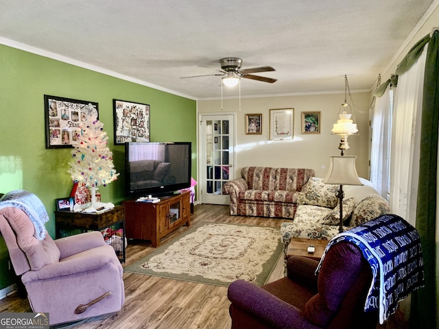 living room with wood-type flooring, ceiling fan, and crown molding