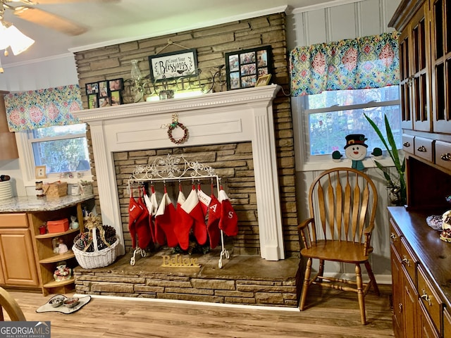 sitting room with hardwood / wood-style flooring, ceiling fan, a healthy amount of sunlight, and crown molding