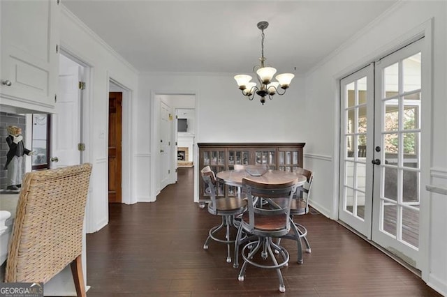 dining space with a chandelier, french doors, dark hardwood / wood-style floors, and crown molding