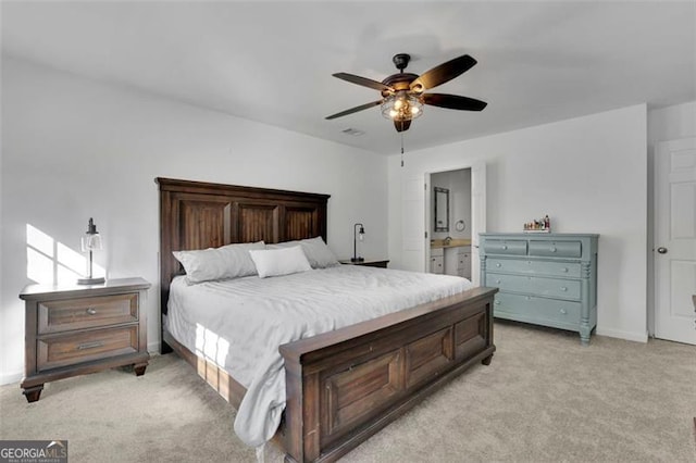 bedroom featuring ceiling fan, light carpet, and connected bathroom