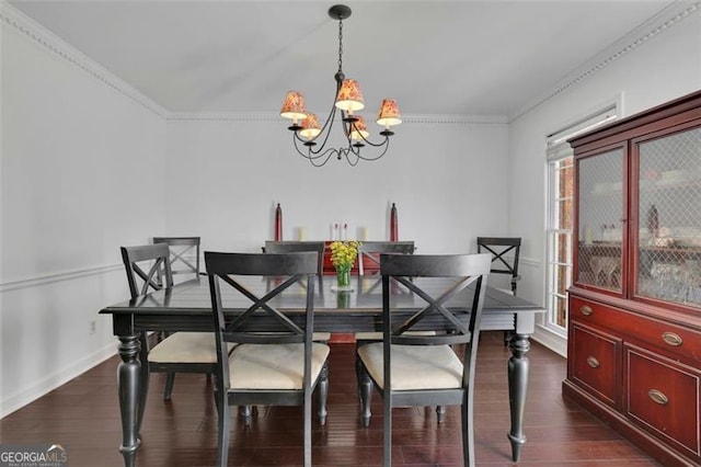 dining room featuring dark hardwood / wood-style floors, ornamental molding, and an inviting chandelier