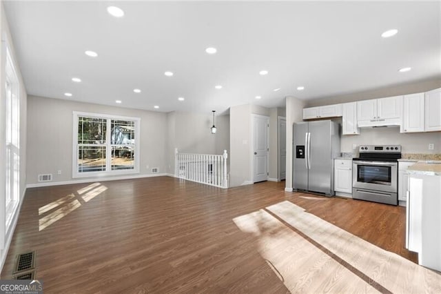 kitchen with white cabinets, appliances with stainless steel finishes, and dark wood-type flooring