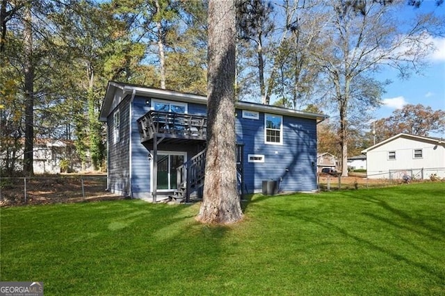 rear view of property featuring a deck and a yard