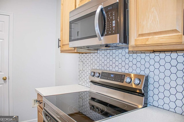 kitchen featuring appliances with stainless steel finishes, tasteful backsplash, and light brown cabinetry