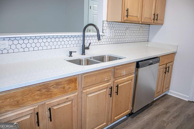 kitchen with tasteful backsplash, light stone counters, stainless steel dishwasher, dark wood-type flooring, and sink