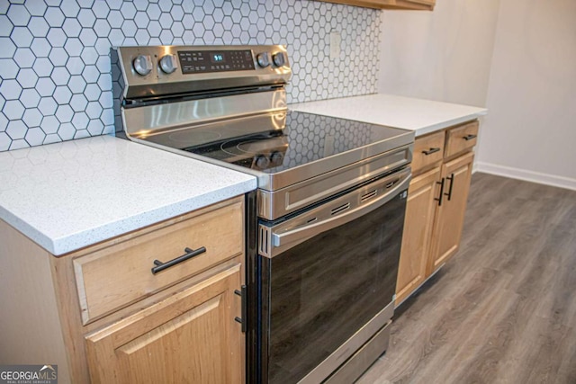 kitchen with light brown cabinets, tasteful backsplash, dark wood-type flooring, and stainless steel electric range