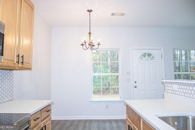 kitchen featuring decorative backsplash, pendant lighting, a healthy amount of sunlight, and dark hardwood / wood-style floors