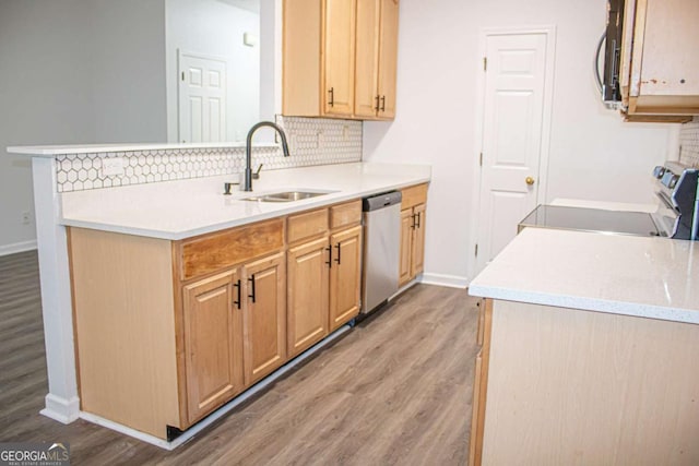 kitchen featuring sink, tasteful backsplash, kitchen peninsula, light hardwood / wood-style floors, and appliances with stainless steel finishes