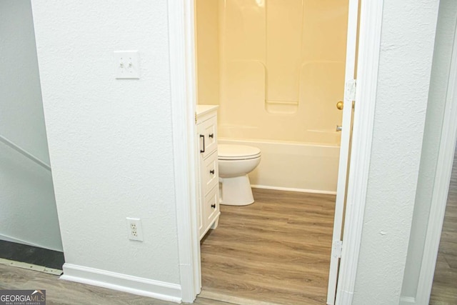 full bathroom with vanity, toilet, wood-type flooring, and bathtub / shower combination