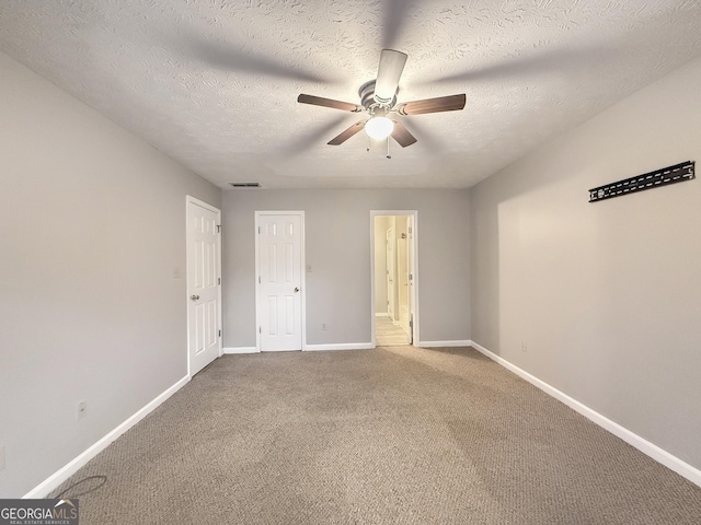 unfurnished bedroom featuring ceiling fan, carpet floors, and a textured ceiling