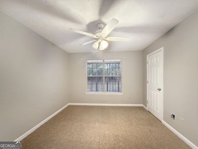 unfurnished room with carpet, ceiling fan, and a textured ceiling