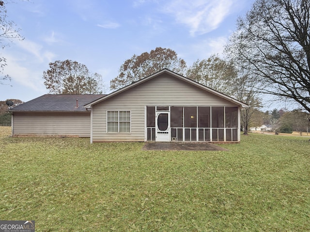 back of property featuring a lawn and a sunroom