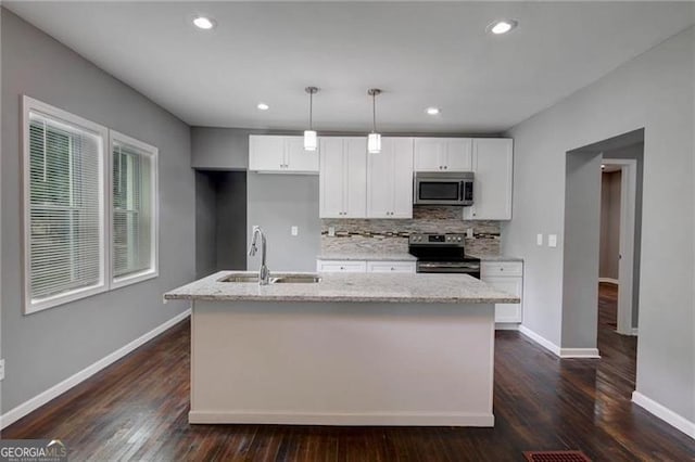 kitchen with a kitchen island with sink, white cabinets, sink, dark hardwood / wood-style flooring, and stainless steel appliances