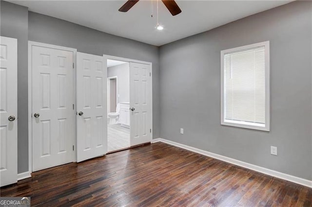 unfurnished bedroom featuring multiple closets, ceiling fan, dark hardwood / wood-style flooring, and ensuite bath